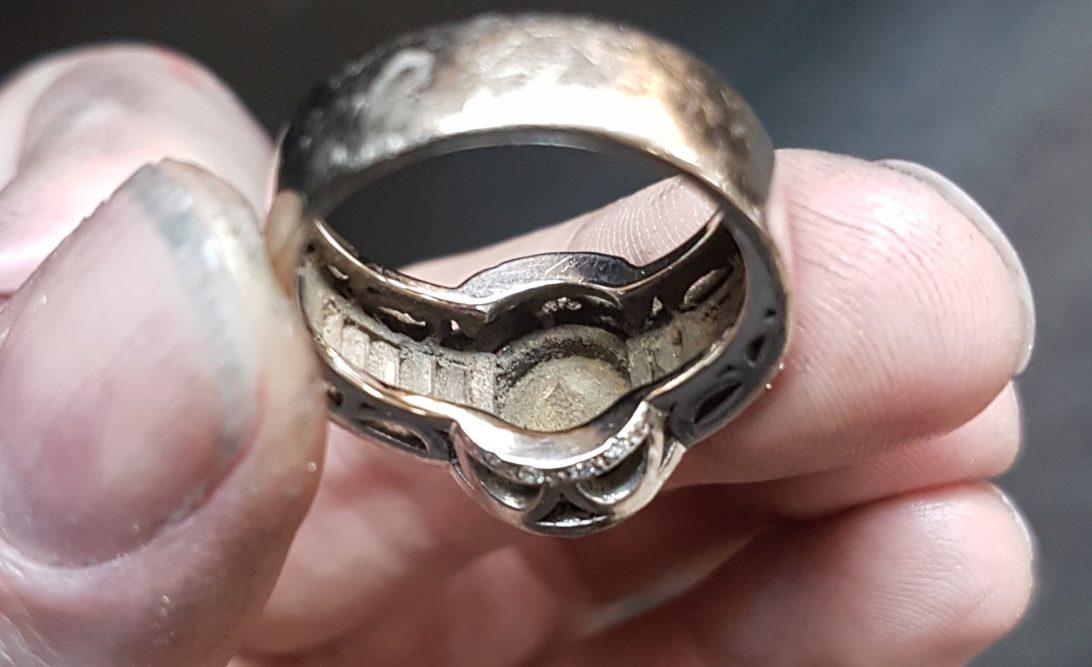 Dirt underneath the settings in a ring